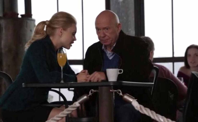 Woman and older man talking at café table