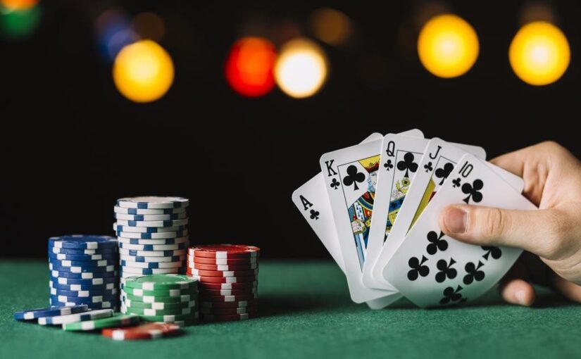 Royal flush of clubs with poker chips
