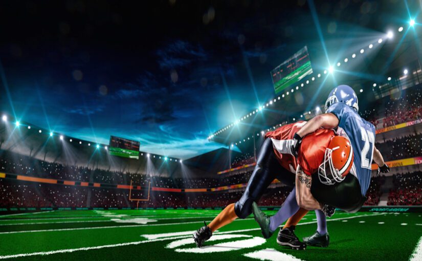 American football tackle under stadium lights