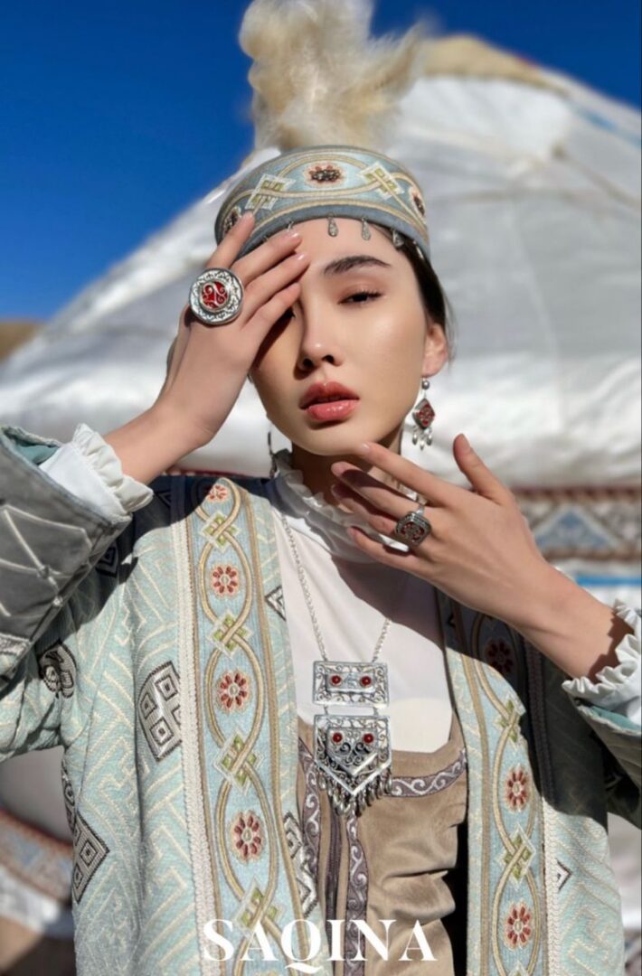 Woman in ornate Central Asian headdress, yurt background
