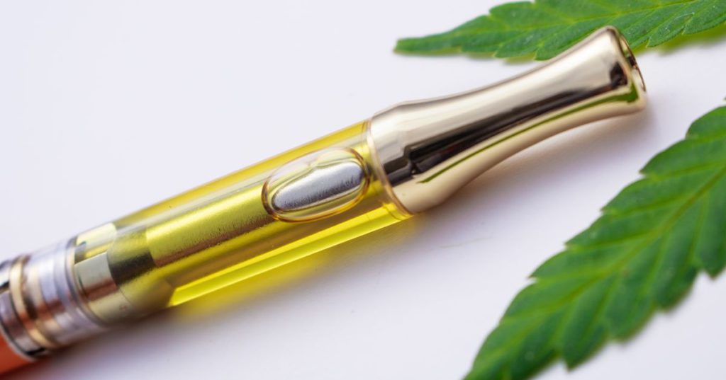 Vape cartridge with cannabis leaf close-up