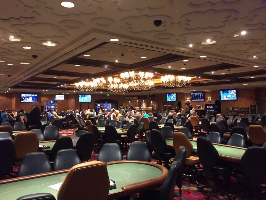 Busy casino poker room with chandeliers