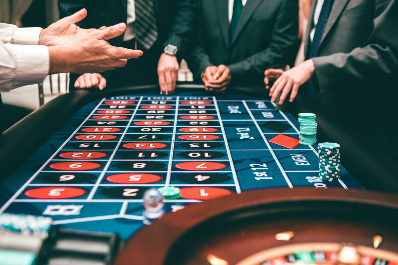 Casino roulette table with players and chips