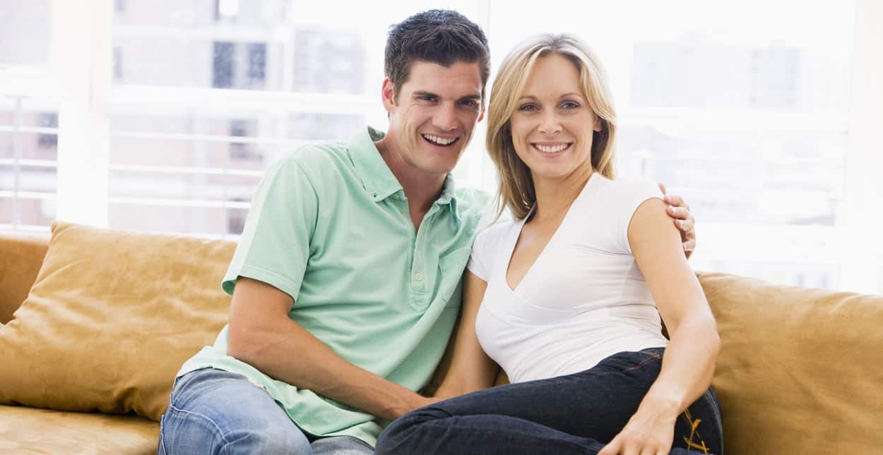 Smiling couple sitting together on couch