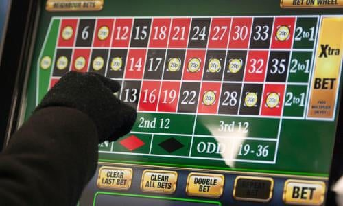 Gloved hand placing bet on roulette touchscreen