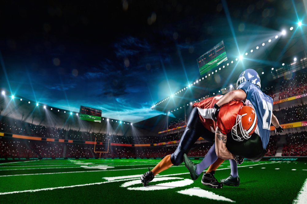 Two American football players tackling on field