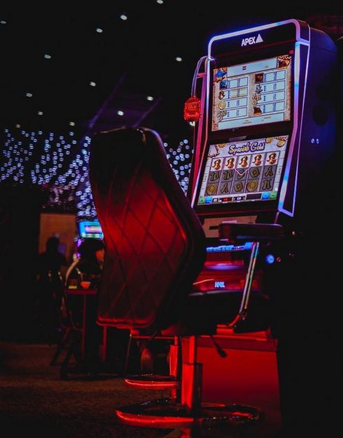 Empty red-lit slot machine and chair