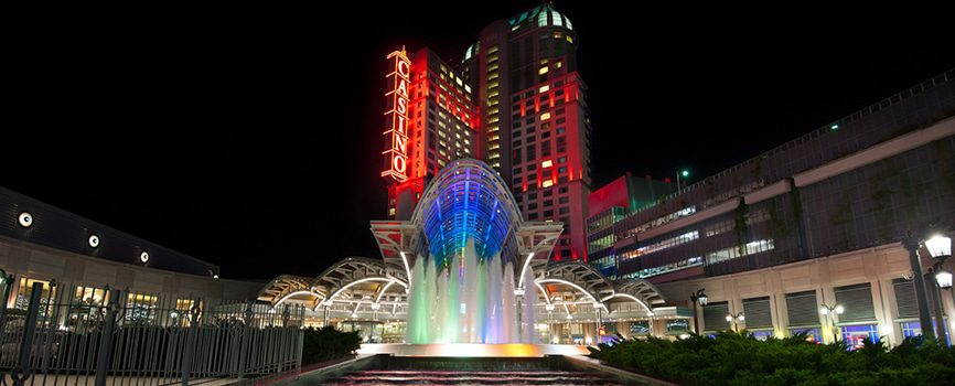Illuminated casino with colorful fountain at night